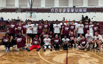 Members of the Maroon and White alumni teams pose for a photo after the game..